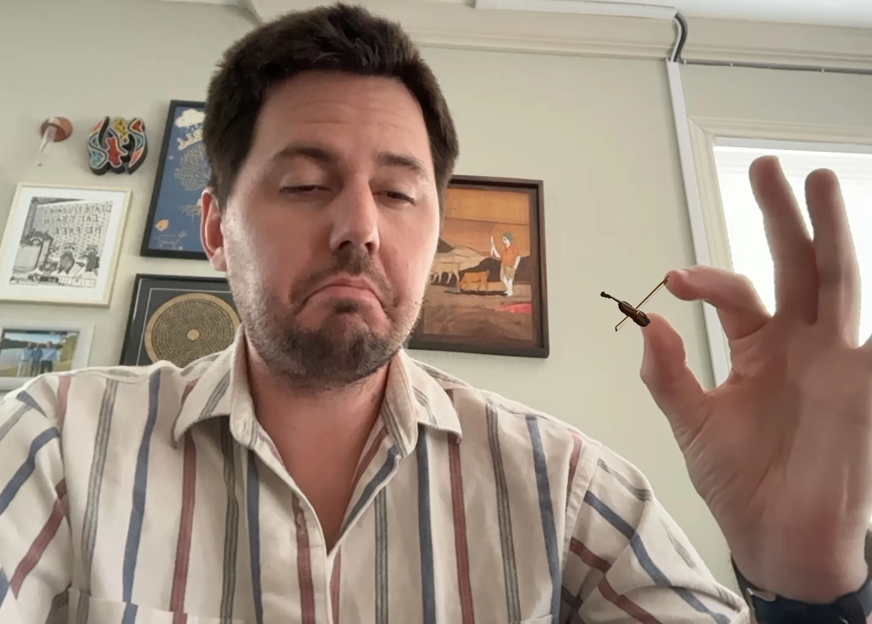 A webcam still of Aidan playing a tiny, digital violin